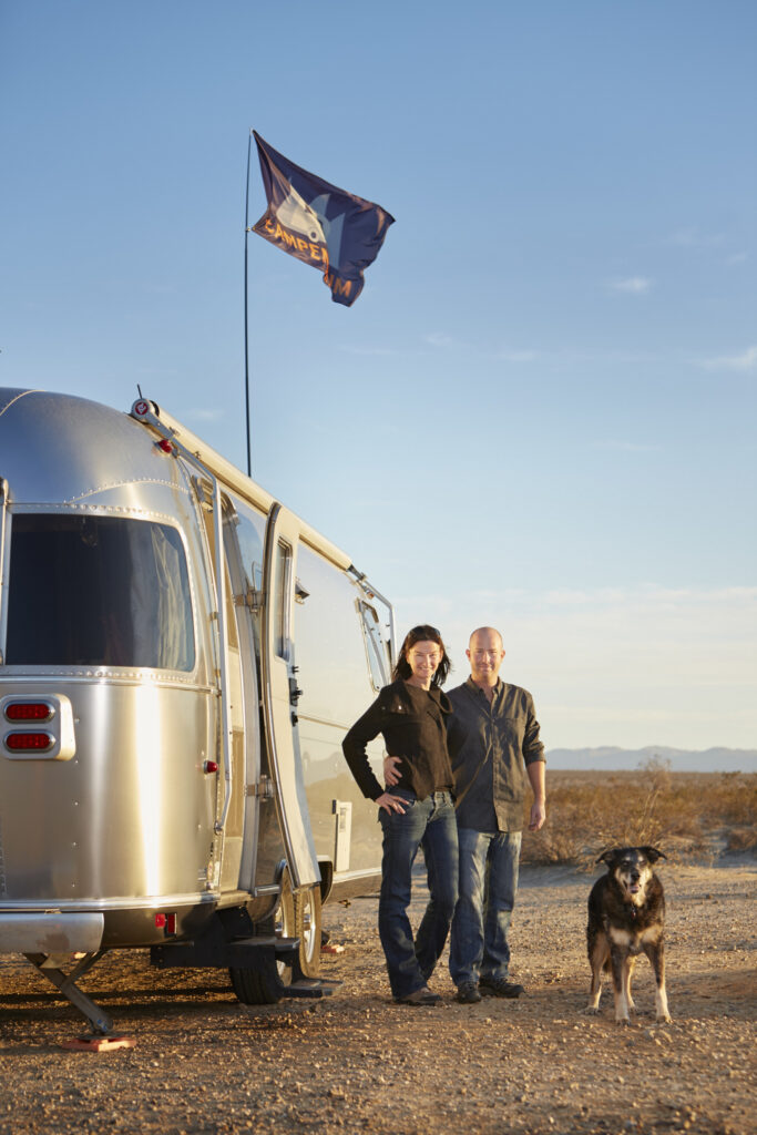 Brian Easterling and Leigh Wetzel stand outside their Airstream RV trailer while camping in the Anza Borrego desert of California.